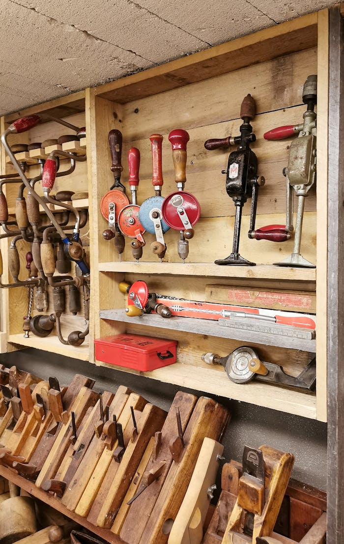 A diverse collection of vintage carpentry tools displayed in a wooden workshop setting.